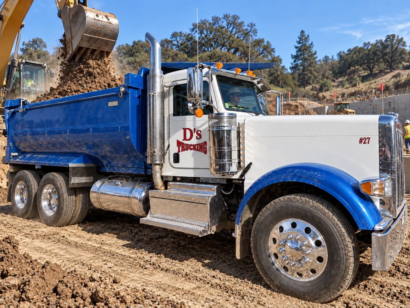 A D’s 10-wheeler taking a load from an excavator on a Bay Area site