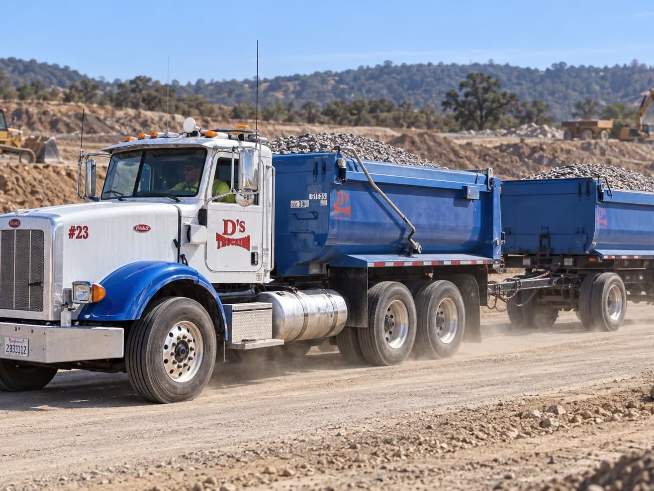 A D’s truck and transfer trailer loaded with rock on a haul road